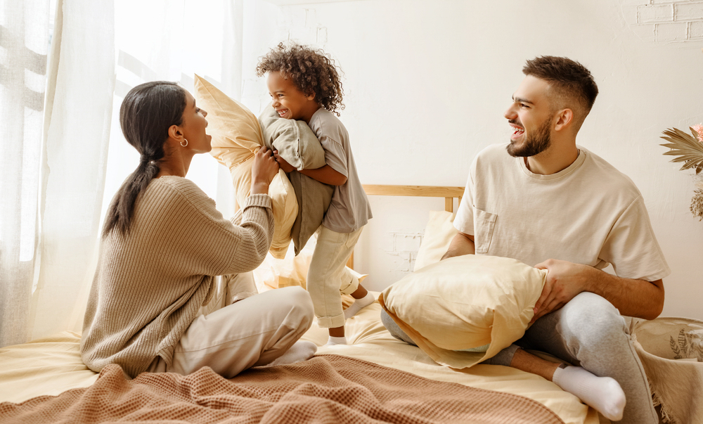 Happy family playing on a bed